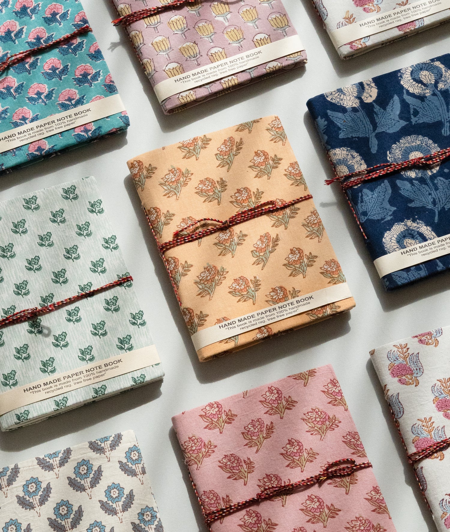 Collection of patterned notebooks with string ties on a light background