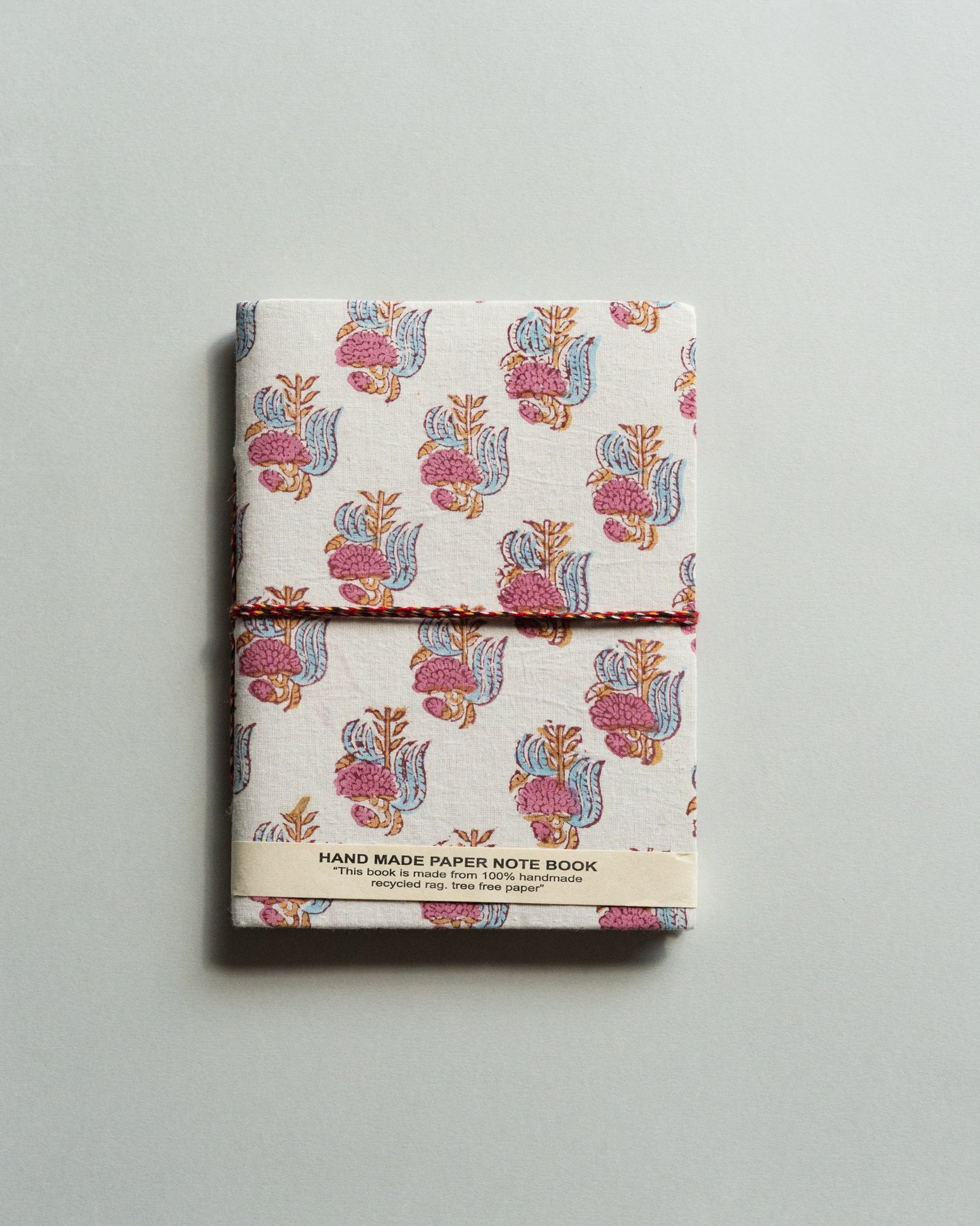 Handmade paper notebook with floral design on a gray background