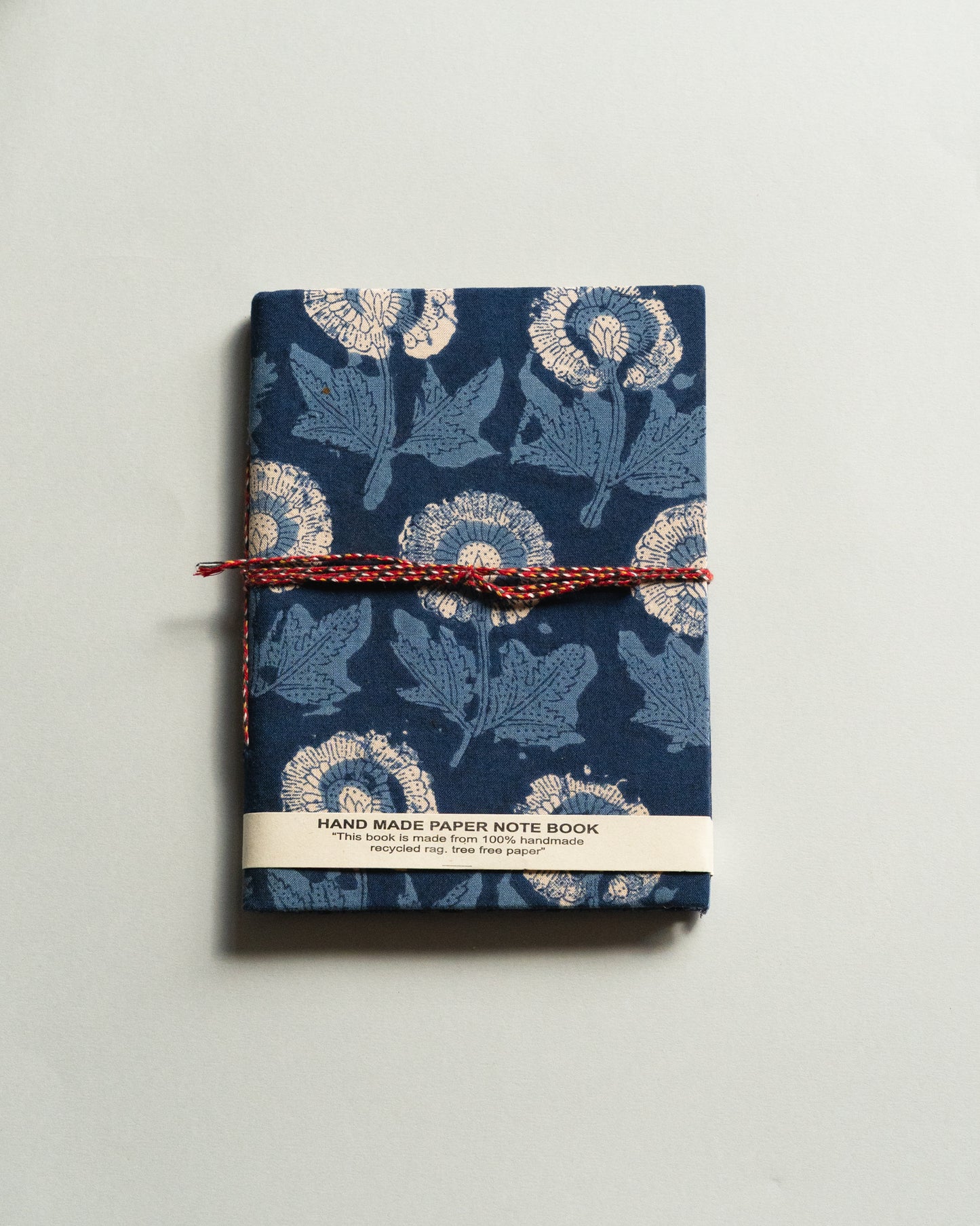 Handmade paper notebook with floral design on a plain background