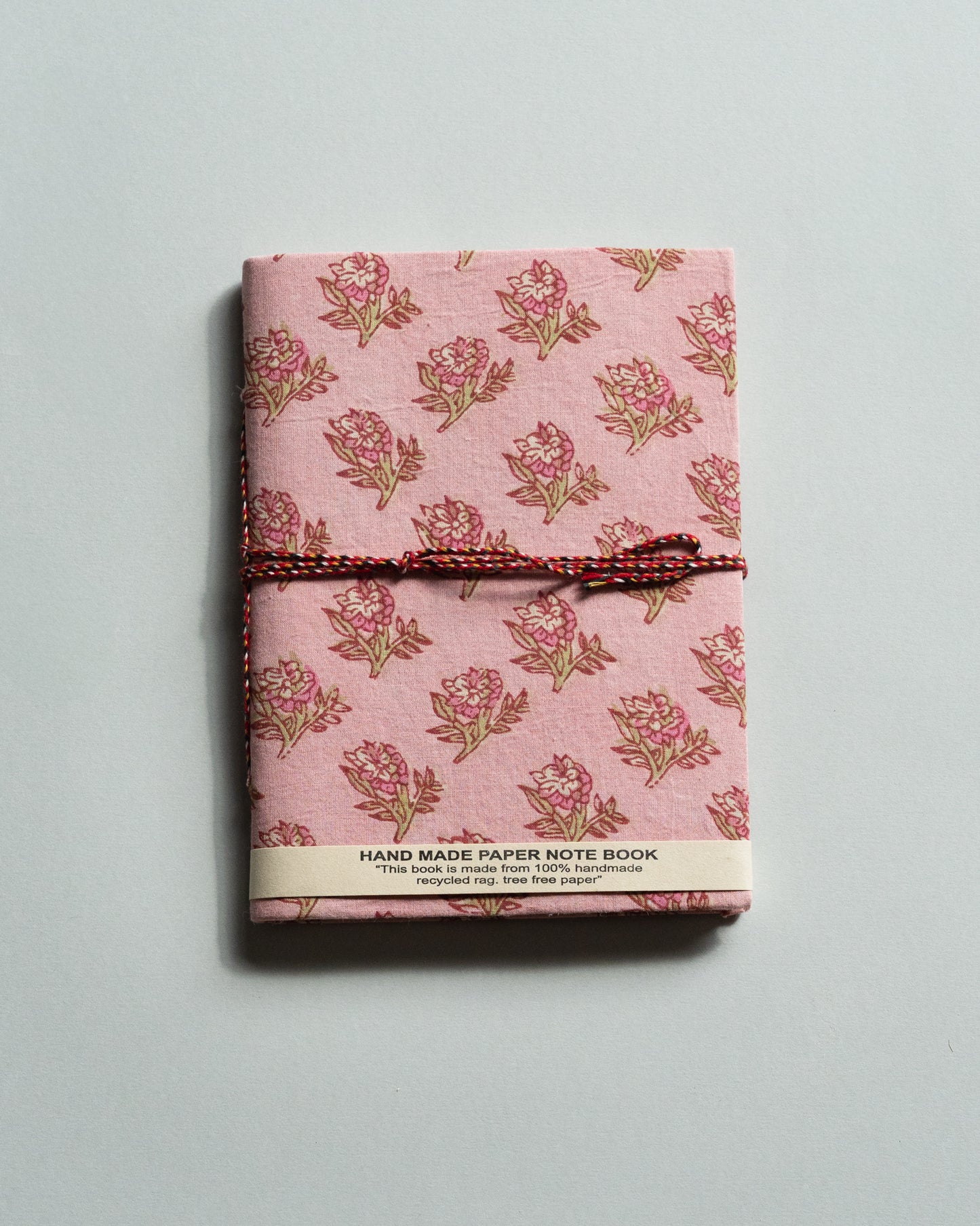 Handmade paper notebook with floral pattern on a light gray background