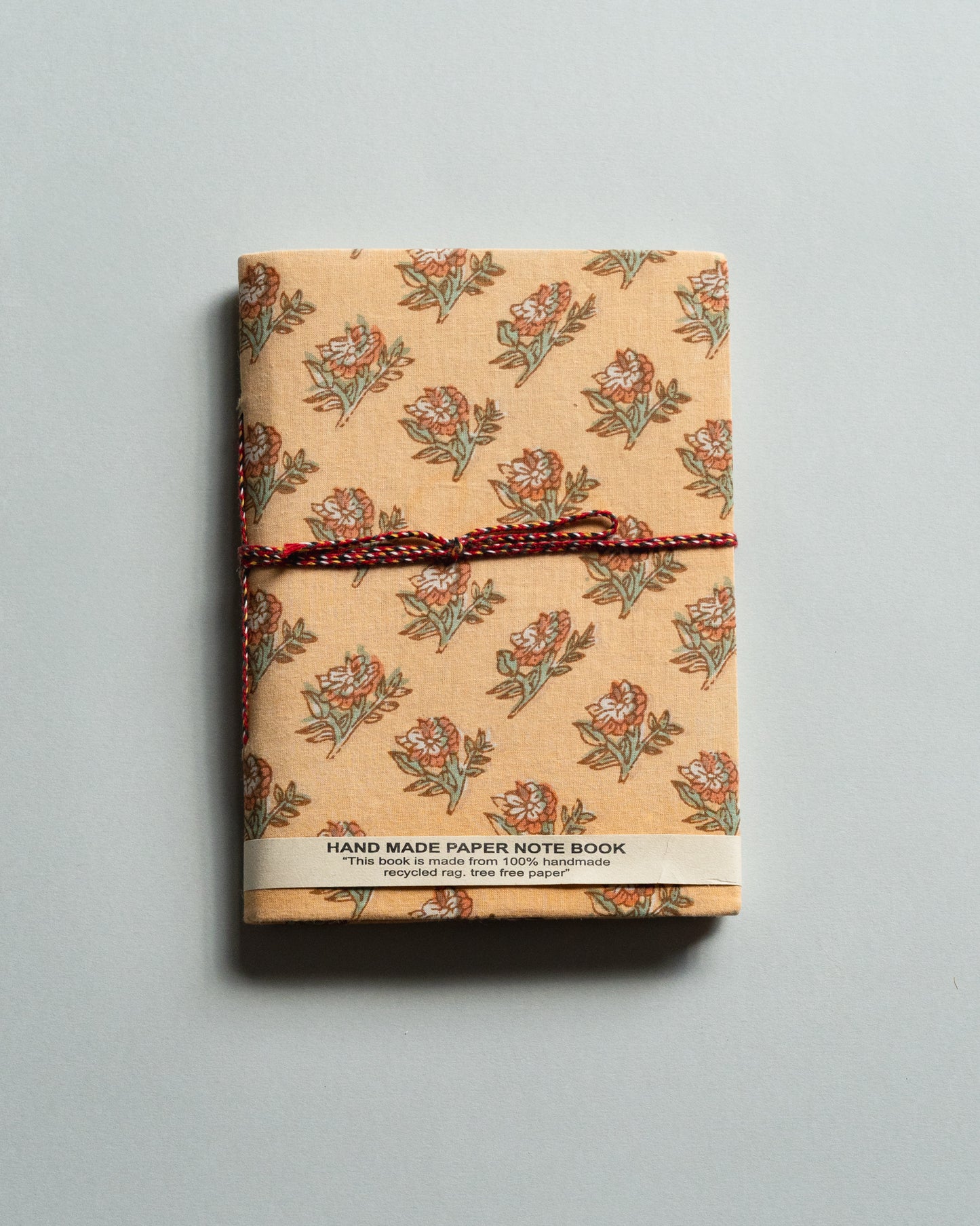 Handmade paper notebook with floral pattern on a gray background