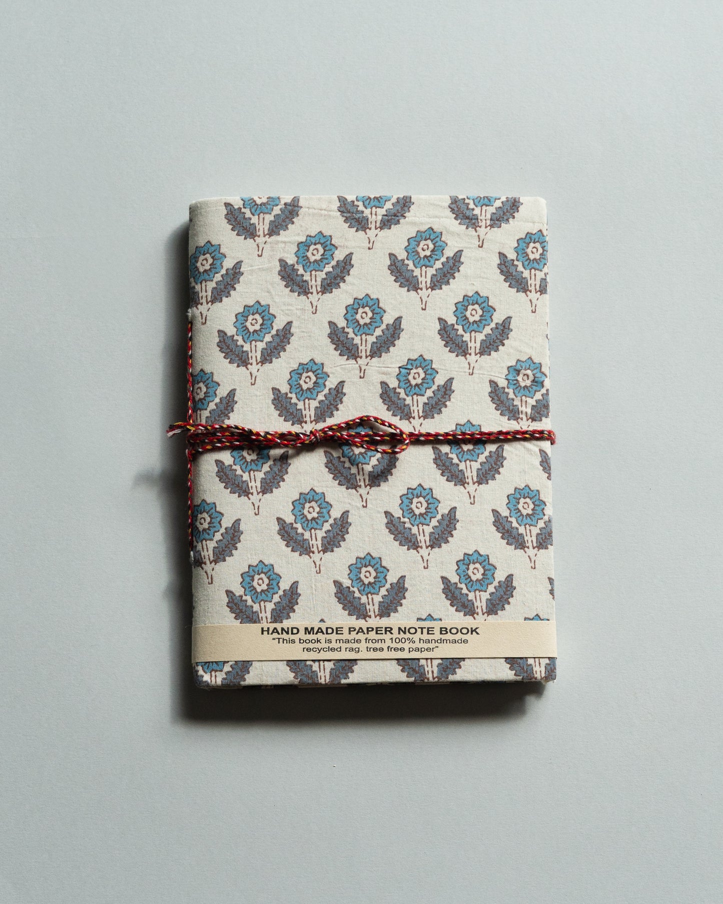 Handmade paper notebook with floral pattern on a gray background