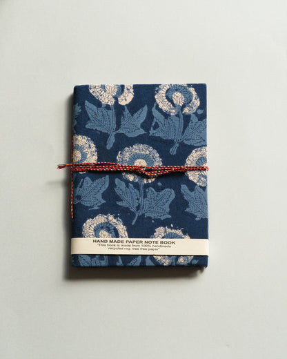 Handmade paper notebook with floral design on a plain background