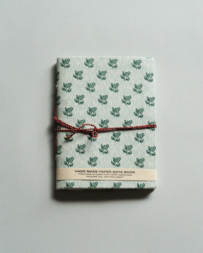 Handmade paper notebook with green leaf pattern on a gray background