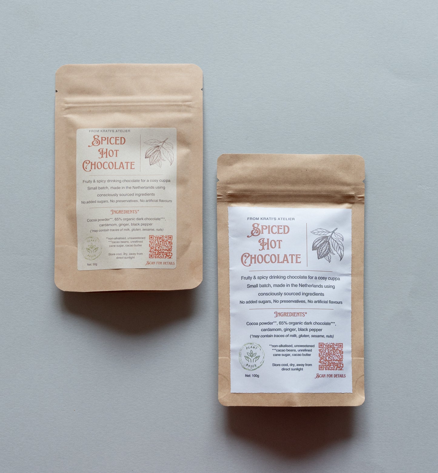 Two packages of spiced hot chocolate on a gray background