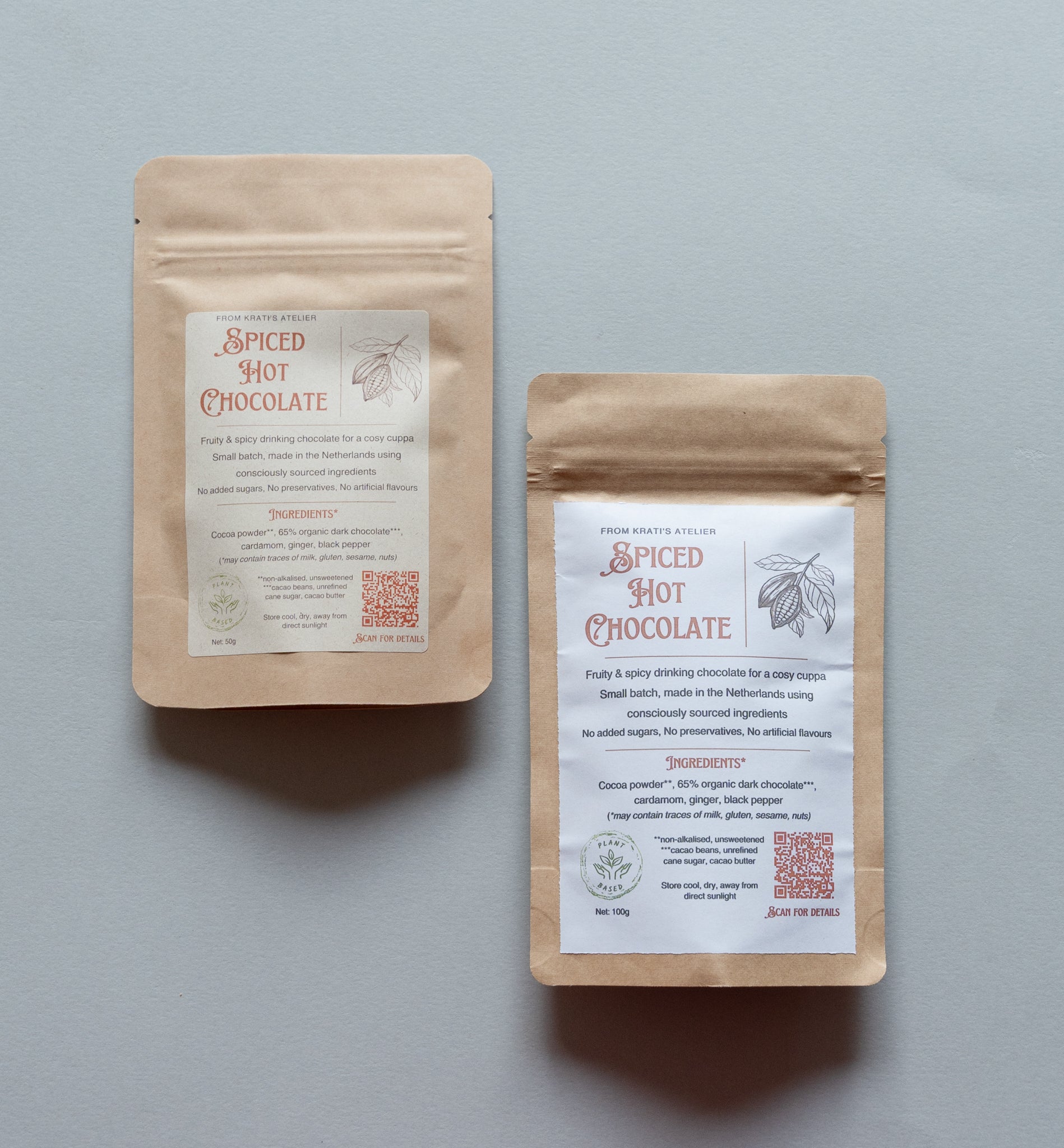 Two packages of spiced hot chocolate on a gray background