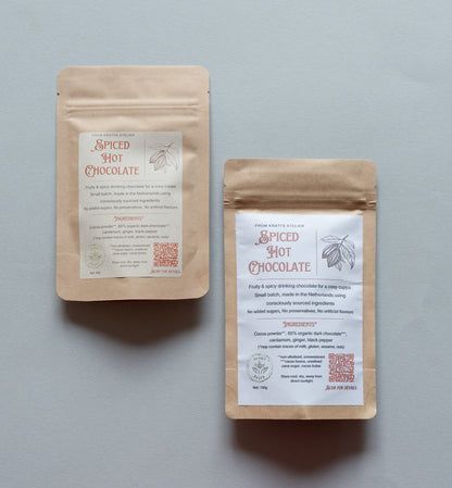 Two packages of spiced hot chocolate on a gray background